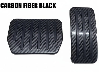 Deux couvre-pédales de véhicule en fibre de carbone noire texturée, présentés sur un fond blanc uni.