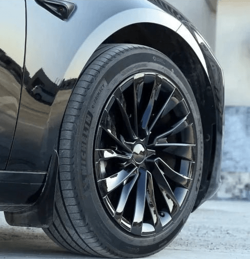 Close-up of a black car wheel with a multi-spoke polished dark alloy rim and a Michelin tire, mounted on a glossy black vehicle body. TESLA MODEL 3 HIGHLAND 18 INCH WHEEL COVERS UBER NOVA PERFORMANCE STYLE GLOSS BLACK FREE DELIVERY WITH FEDEX ACROSS EUROPE FROM IRELAND AND EUROPES TESLARY.EU THE TESLA ACCESSORIES SPECIALISTS