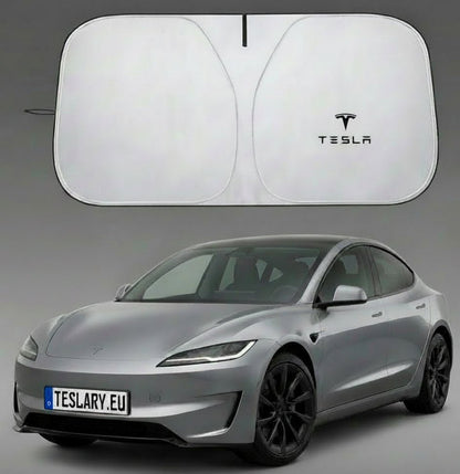 Une Tesla argentée est présentée avec un grand pare-soleil blanc au-dessus, dont une vue repliée est visible à gauche. Le logo Tesla noir est imprimé sur le pare-soleil.